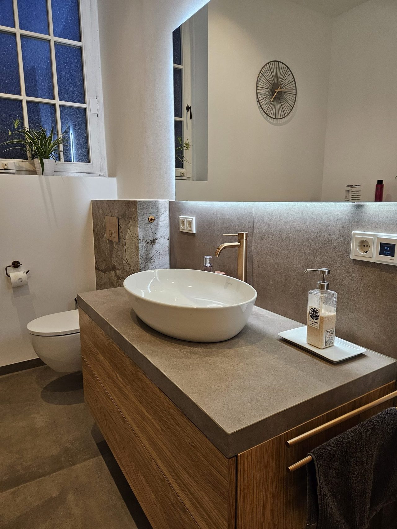 Altbau-Badsanierung mit Messingdetails – Waschtischbereich mit Betonoptik-Platte und Marmoroptik-Akzent