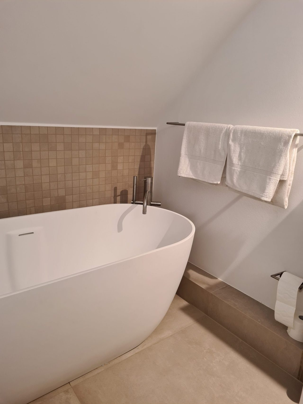 Badsanierung im Japandi-Stil – Freistehende Badewanne vor Mosaikwand
